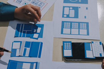 Group of young application developers analyzing uxui mobile app templates during a working meeting