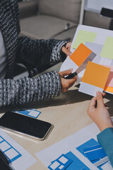 Group of young application developers analyzing uxui mobile app templates during a working meeting