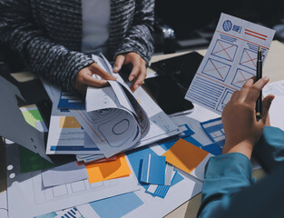 Group of young application developers analyzing uxui mobile app templates during a working meeting