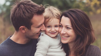 Fototapeta premium Happy family portrait featuring a smiling toddler with loving parents outdoors in a natural environment, exuding warmth and togetherness.