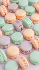 Pastel macarons arranged on a light pink background