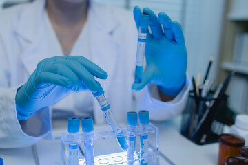 a female scientist is working in lab, a chemist tests liquid sample in science laboratory, she...