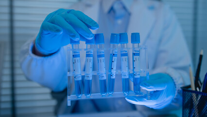 a female chemist is testing various liquid compounds in a lab, a scientist is doing research on the...