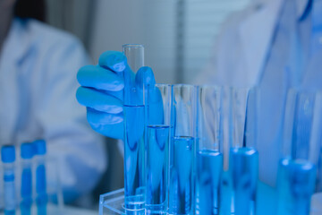 when in a lab, scientists wear lab coats, rubber gloves, and safety goggles, two chemists are...