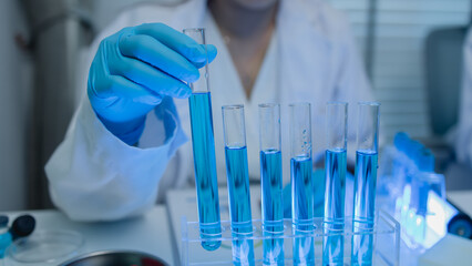 when in a lab, scientists wear lab coats, rubber gloves, and safety goggles, two chemists are...