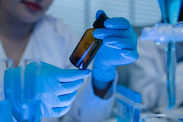 a female chemist is testing various liquid compounds in a lab, a scientist is doing research on the...