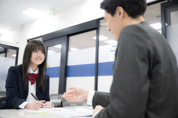 学生の面談や個別指導、進路指導の塾などのイメージ　笑顔で話す