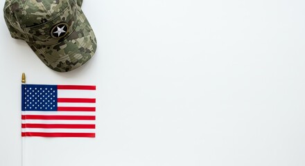 A flat lay composition of a military-style veteran cap placed beside a carefully laid small U.S. flag on a white background.