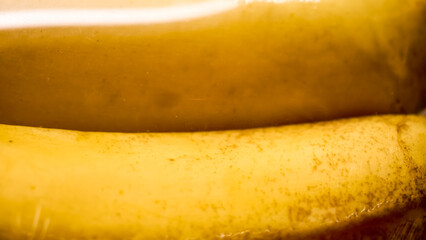 A detailed close-up of two ripe bananas, highlighting their vibrant yellow color, textured peel,...