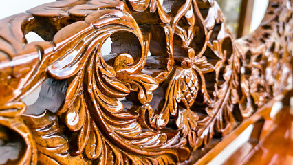 Detailed wood carving showcasing floral designs and swirling leaf patterns on furniture