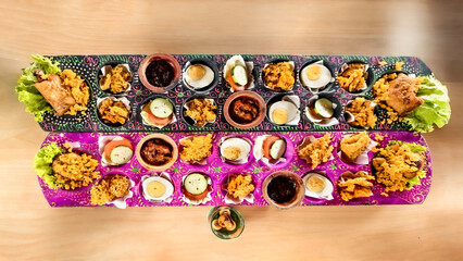 An exotic culinary journey of Indonesia, serving crispy chicken on congklak with bright colors and unique plating