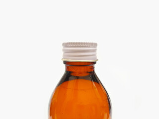 Amber glass bottle with an aluminum cap isolated on a white background, close up, brown glass bottle for pharmaceuticals, syrups, essential oils, and cosmetics