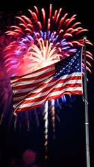Celebratory Fireworks Illuminate the Night Sky Behind a Proud American Flag, Creating a Vivid Display of Color and Patriotism in a Joyous Atmosphere.