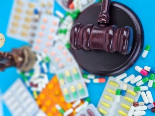 Legal judgment on pharmaceuticals amid assorted medication on a blue background concept