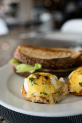 Egg benedict on a plate. Featuring poached eggs and hollandaise sauce. Selective focus
