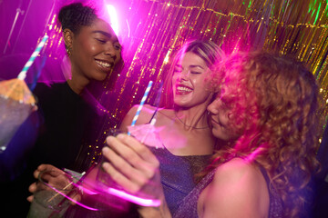 Friends enjoying cocktails at a nightclub party