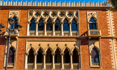 old yellow facade of house with beautiful vintage windows in retro italian european style. Side facade of and old palace in Europe.
