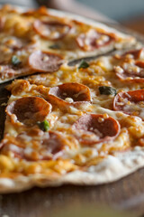 Close up of pepperoni pizza on wooden serving board