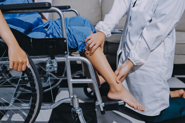 Physiotherapist checking knee of female patient stock