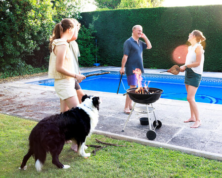 Family enjoying barbecue by the pool with their Border Collie dog