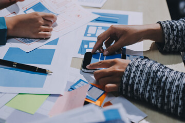 Group of young application developers analyzing uxui mobile app templates during a working meeting