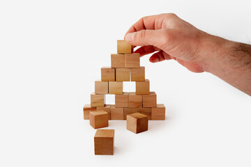 Hand of man stacking wooden blocks.Business and development concept.