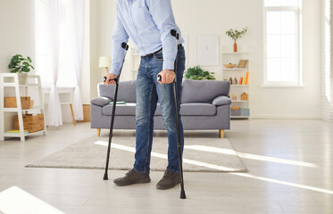 Disabled man home rehabilitation after trauma, injury, male patient learns walking with two forearm...