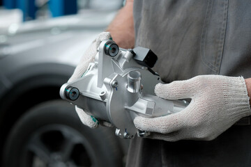 Car service, maintenance. Vehicle cooling system. The pump is electric. An auto mechanic holds a...