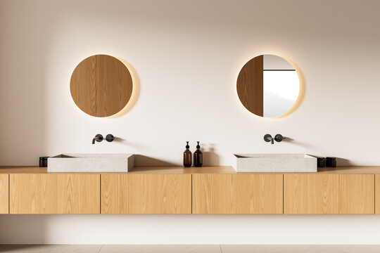 Minimalist double sink bathroom interior with wood and stone elements, backlit mirrors and soft lighting on beige wall background. 3D Rendering