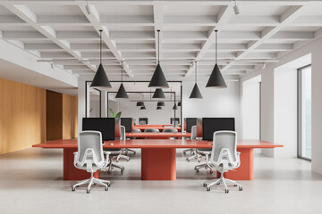 Modern open space office interior with red desks, ergonomic white chairs, and geometric ceiling...