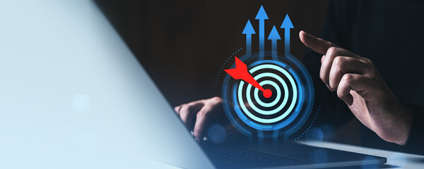 Business goal achievement concept with digital target and arrow interface on laptop screen in...