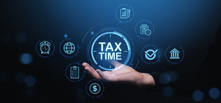 Hand holding glowing "Tax Time" icon with finance and schedule symbols on dark blue background, representing tax preparation and financial planning concept.