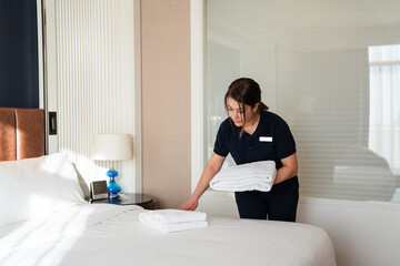 The housekeeper cleans the room and changes the sheets and towels.