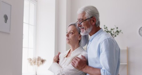 Happy and smiling senior Caucasian couple, husband and wife, embracing and smiling together at cozy home. Their love and happiness are evident, highlighting the joy of being together. - Powered by Adobe