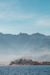 The medieval citadel of Calvi on the west coast of the Mediterranean island of Corsica with mountains behind