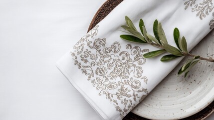  Elegant white linen napkin with intricate brown embroidery, resting on an antique plate, adorned with an olive branch, product design shoot, detailed and realistic, natural lighting,