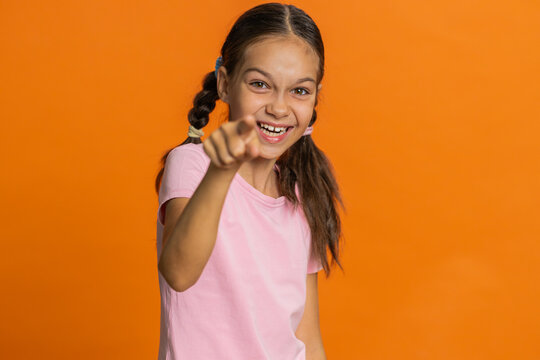 Happy preteen child girl kid laughing out loud after hearing ridiculous anecdote reaction on funny joke feeling carefree amused. Positive people. Teenager children isolated on studio orange background