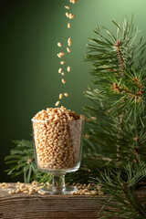 Pine nuts is poured in a glass bowl.
