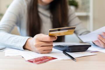 Financial owe, hand of asian woman sitting, holding credit card, stressed by calculate expense from...