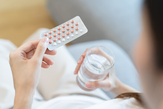 young female holding birth control pills - Powered by Adobe