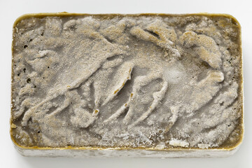 A frozen block of cooked and high-speed-blended white mustard greens, covered with frost while...