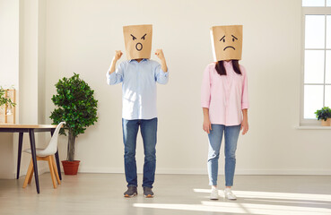 Faceless man in bag on head with angry face expression standing near upset unhappy frustrated woman...