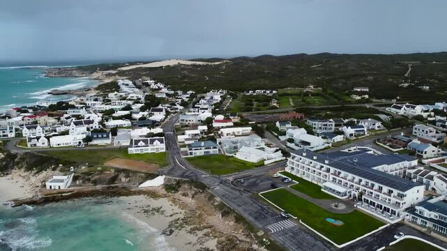  Camera panning left to right over the town of Waenhuiskrans, Arniston, a coastal town, 4K Aerial Video
