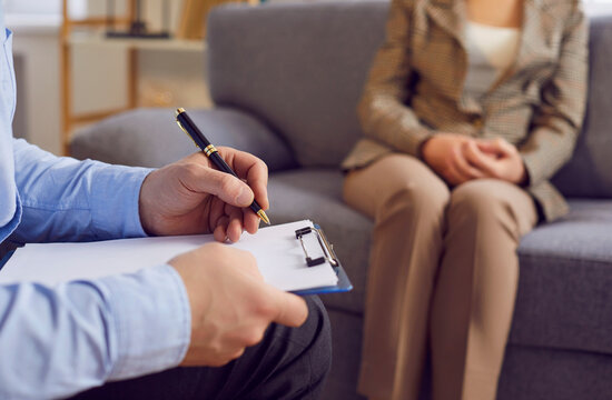 Psychiatrist, psychiatric doctor session for mental health professional help, writing form close up. Diagnosing and treating psychiatric disorders, discussing symptoms with patient woman on couch 