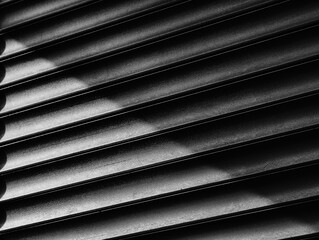 Diagonal light ray on black and white blinds surface