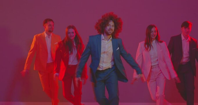 People group of vibrant dancers in colorful costumes dancing together under neon lights. The energetic atmosphere, pulsating music, and synchronized dance create a disco party scene.