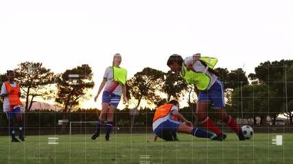Four female players chasing rolling ball in soccer drill executing slide tackle rising at sunset - Powered by Adobe