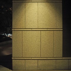 照明に照らされたビルの壁、夜の静寂と光彩。イラスト風の写真。カラーハーフトーン。