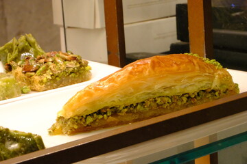Traditional Turkish delight baklava. Şöbiyet, ice cream hamburger baklava, pistachio baklava, burma kadayıf, bread dessert, almond shekerpare. Ramadan, iftar. Turkish desserts with syrup.
