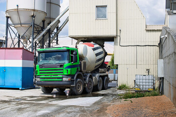 Cement truck delivers concrete at construction site in industrial area during daytime